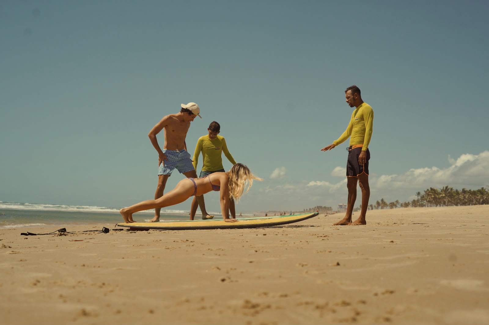 Instrutores da Fassola orientando aluna na areia antes de entrar no mar